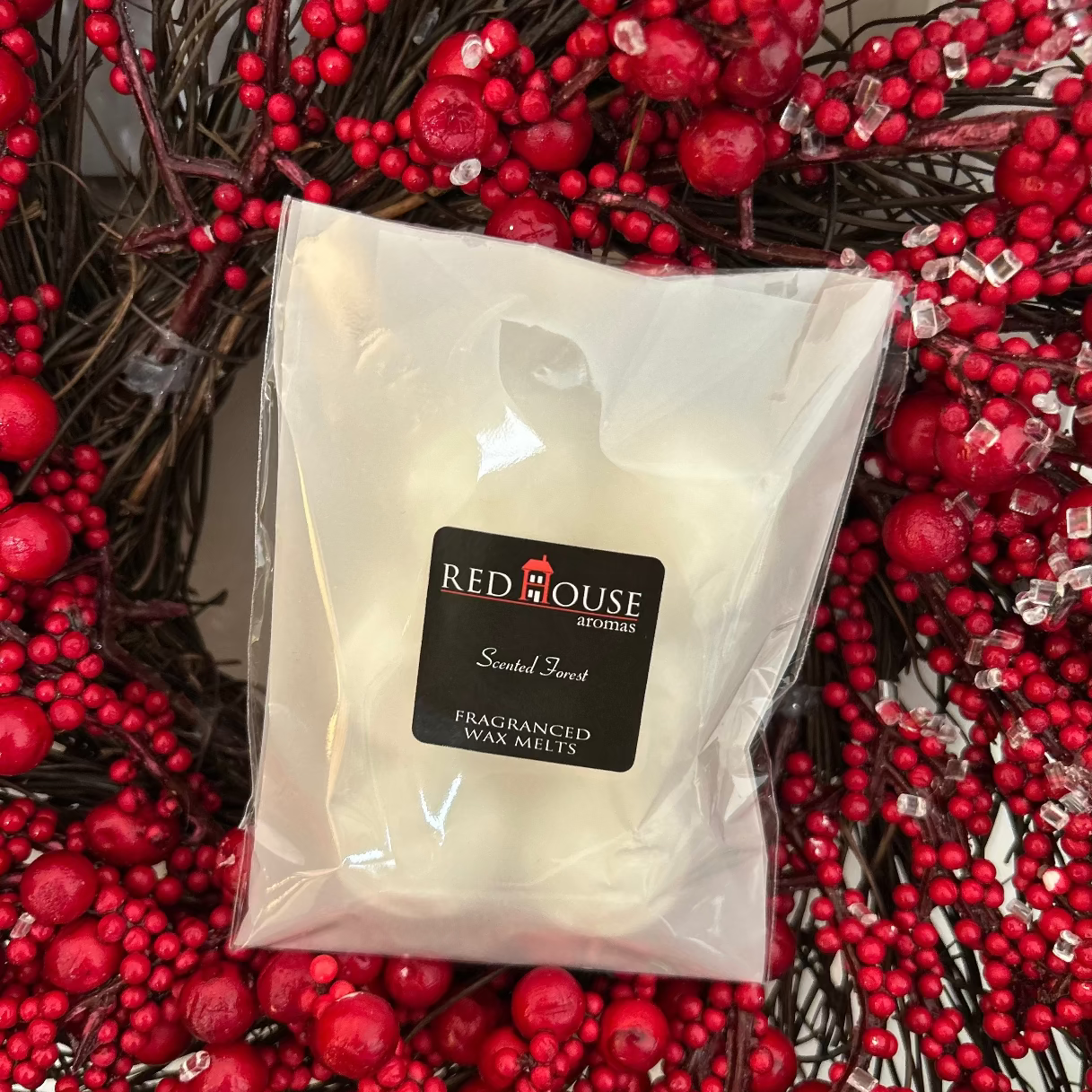 White wax melt packet with Red House logo on a red berry background