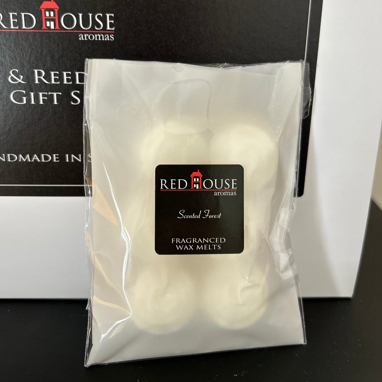 Packaged white scented wax melts with Red House Aromas.